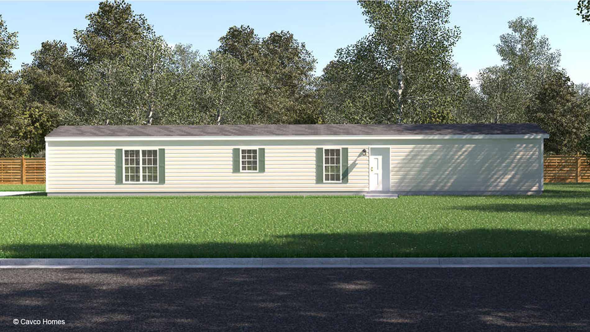 Charming single-story manufactured home with beige siding, green shutters, and a grassy lawn, surrounded by mature trees.